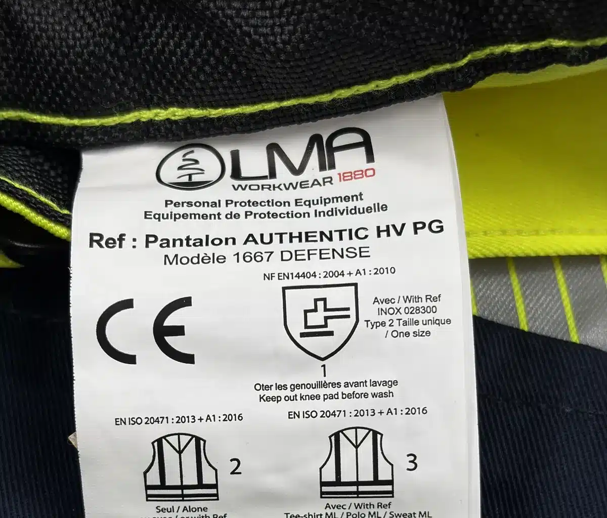 Étiquette d'un pantalon haute visibilité LMA Defense : pictogramme EN ISO 20471 classe 2 porté seul, classe 3 avec une veste haute visibilité